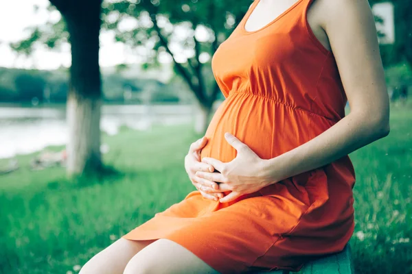 Pregnant woman, holding in hands bouquet of daisy 
