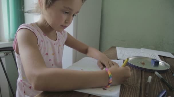 Flickan gör läxor för grundskolan. — Stockvideo