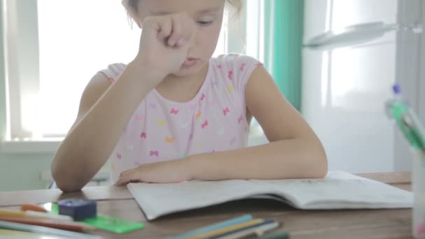 Flickan gör läxor för grundskolan. — Stockvideo