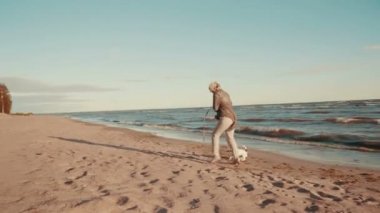 Mutlu kadın ile köpek sahilde oynarken