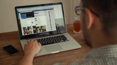 Laptop ile çalışan adam ahşap masanın üstüne yerleştirilir. Saint Petersburg, Rusya Federasyonu - 29 Ağustos 2015