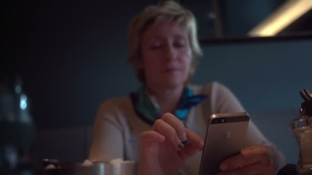 RUSSIA, SAINT PETERSBURG - AUGUST 31, 2015: Adult woman using smartphone in cafe — Stock Video