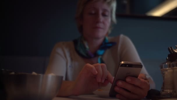 RUSIA, SAN PETERSBURG - 31 de agosto de 2015: Mujer adulta usando smartphone en la cafetería — Vídeos de Stock