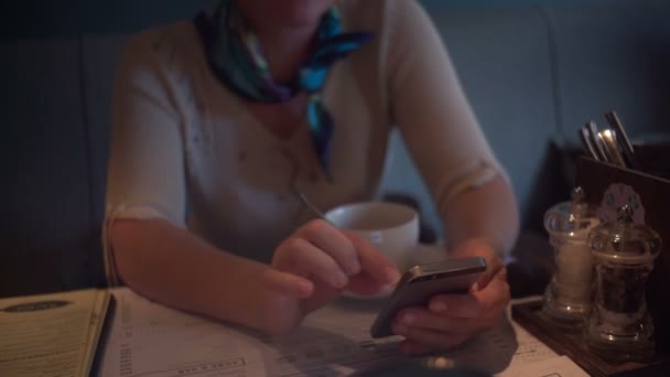 Rusland, Sint-Petersburg - 31 augustus 2015: Volwassen vrouw met behulp van smartphone in café — Stockvideo