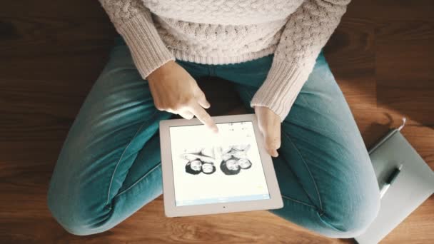 Woman sitting on the floor and using tablet pc, top view. SAINT PETERSBURG, RUSSIA - AUGUST 29, 2015f — Stock Video