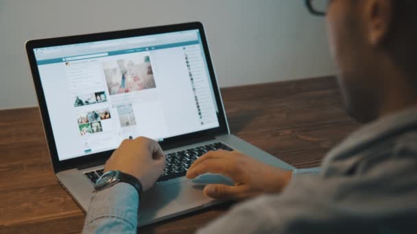 Homem vendo a rede social do Facebook em um laptop . — Vídeo de Stock