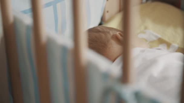 Новорожденный спит в своей кроватке — стоковое видео