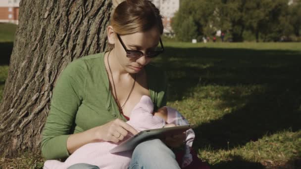 Chica en el parque y el uso de la tableta PC — Vídeos de Stock