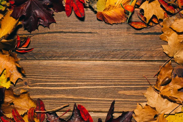 Background with wooden table and autumnal leaves — Stock Photo, Image