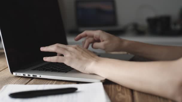 Woman working with laptop placed on wooden desk