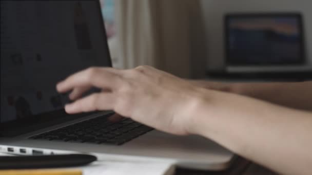 Vrouw die werkt met laptop geplaatst op houten bureau — Stockvideo