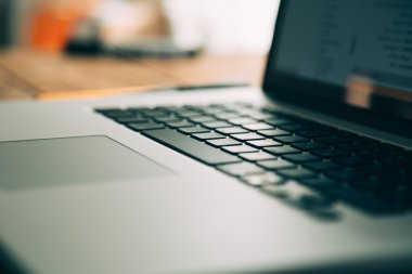Modern ahşap masa üzerinde açık dizüstü bilgisayar ile işyeri