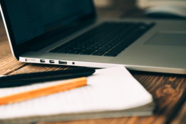 Modern ahşap masa üzerinde açık dizüstü bilgisayar ile işyeri