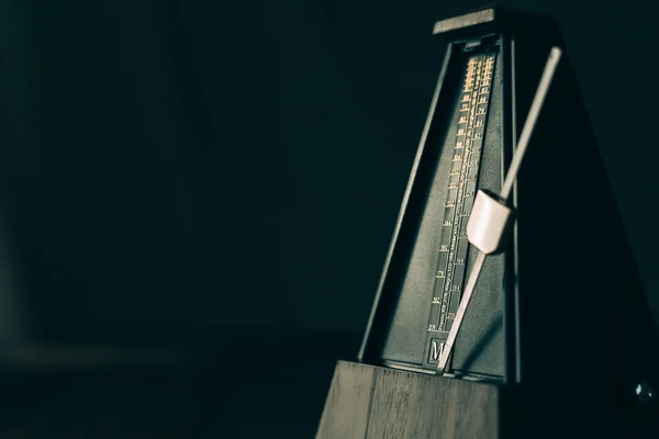 Vintage metronome, on a dark background. — Stock Photo, Image