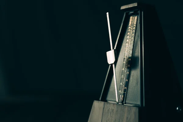 Vintage metronome, on a dark background. — Stock Photo, Image