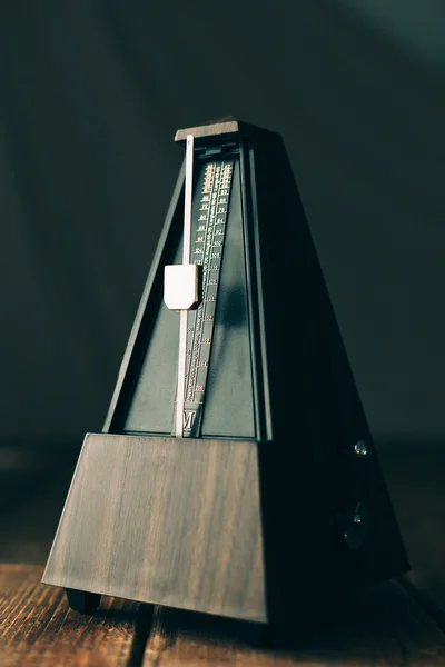 Metrónomo vintage, sobre un fondo oscuro . — Foto de Stock