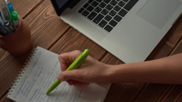 木製の机の上に置かれたノート パソコンで働く女性 — ストック動画