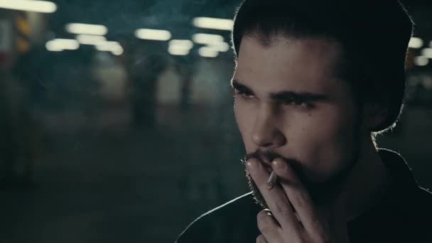 Молодой красивый бородатый мужчина курит сигарету — стоковое видео