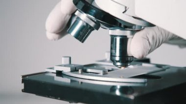 Bilim adamı laboratuvarda mikroskop kullanıyor.