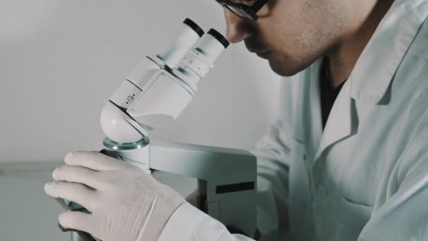 Jeune médecin regardant à travers le microscope 