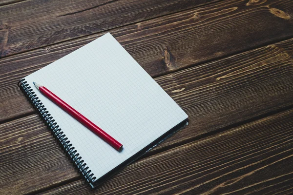 Notitieboekje met pen en koffie op oude houten tafel — Stockfoto