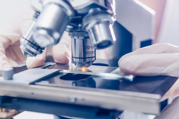 Mãos de cientista com microscópio — Fotografia de Stock