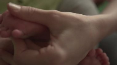 Anne bebeğini ayak masajı eller