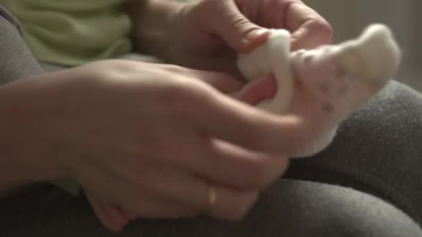 Moeder de sokken zetten haar kleine baby — Stockvideo