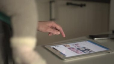 Tablet bilgisayar kullanarak bebeği olan kadın