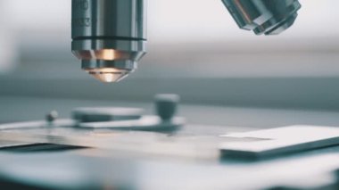 Bilim adamı laboratuvarda mikroskop kullanıyor.