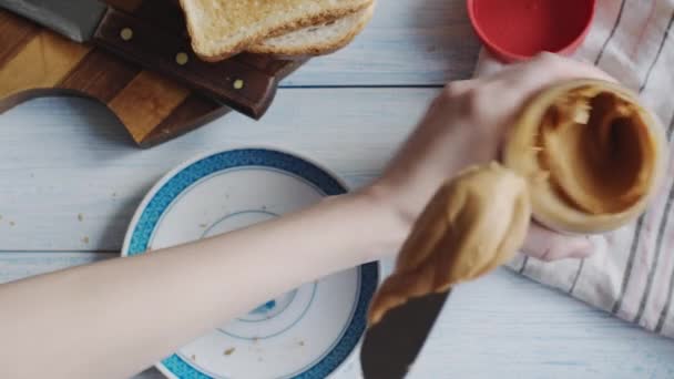 Mujer hace un sándwich de mantequilla de maní — Vídeos de Stock