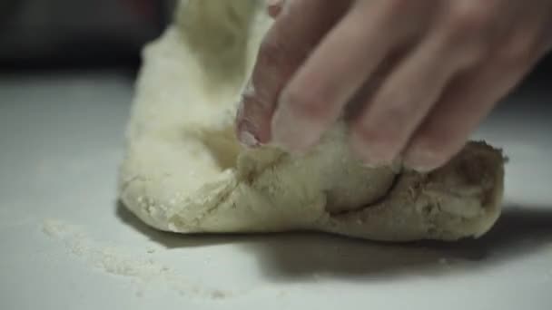 Женщина месит тесто на столе — стоковое видео