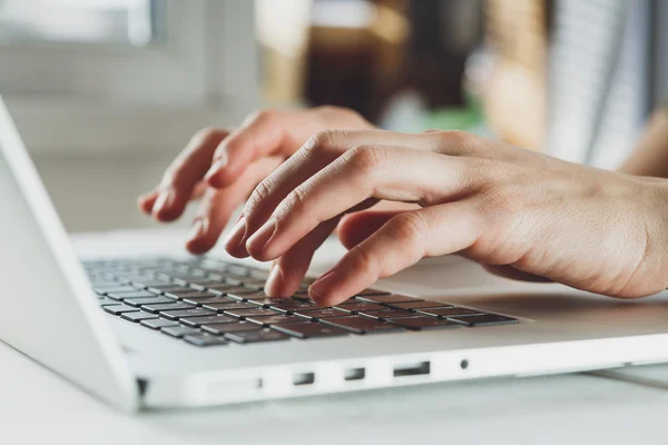 womans hands working on laptop computer