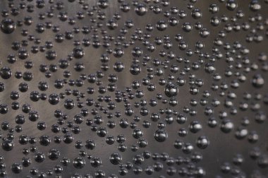 Karanlık bir odada, bir bardak suyun içinde hava kabarcıkları..