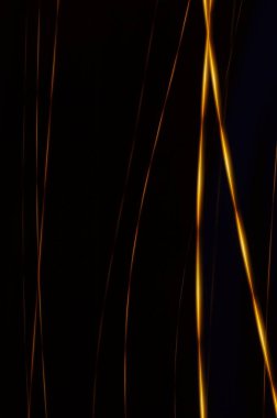 Siyah arkaplanda altın iplikler - kaos içinde altın ve turuncu neonları gösteren soyut grafik arkaplan