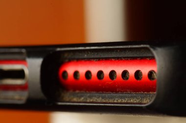 Cep telefonu, Jack ve hoparlörleri şarj ediyor. Kırmızı, koruyucu ambalajda kullanılmış telefon. Elektronikler yakın plan.