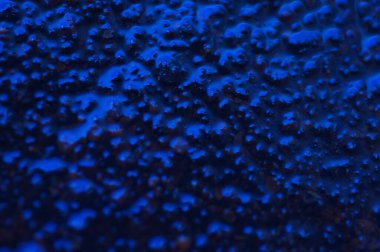 Soyut mavi gizemli arka plan. Koyu ışıkta pürüzlü bir doku. Yağlı, yağlı kabarcıklar ve kabarcıklarla dolu. Yansıyan mavi ışıkla birlikte koyu ve düz olmayan bir arka plan. Jestsel dokuya sahip 3d illüstrasyon.