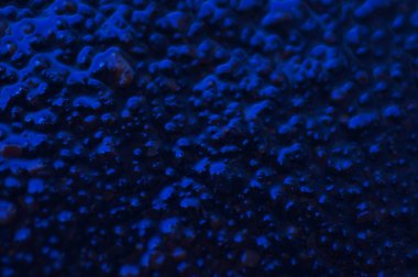 Soyut mavi gizemli arka plan. Koyu ışıkta pürüzlü bir doku. Yağlı, yağlı kabarcıklar ve kabarcıklarla dolu. Yansıyan mavi ışıkla birlikte koyu ve düz olmayan bir arka plan. Jestsel dokuya sahip 3d illüstrasyon.