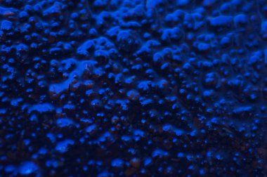 Soyut mavi gizemli arka plan. Koyu ışıkta pürüzlü bir doku. Yağlı, yağlı kabarcıklar ve kabarcıklarla dolu. Yansıyan mavi ışıkla birlikte koyu ve düz olmayan bir arka plan. Jestsel dokuya sahip 3d illüstrasyon.