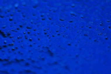 Soyut mavi gizemli arka plan. Koyu ışıkta pürüzlü bir doku. Yağlı, yağlı kabarcıklar ve kabarcıklarla dolu. Yansıyan mavi ışıkla birlikte koyu ve düz olmayan bir arka plan. Jestsel dokuya sahip 3d illüstrasyon.