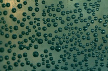 Suda hava kabarcıkları. Bir bardak suda metal kabarcıklar. Soda, yakın plan, koyu arkaplanda..