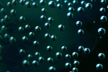 Suda hava kabarcıkları. Bir bardak suda metal kabarcıklar. Soda, yakın plan, koyu arkaplanda..