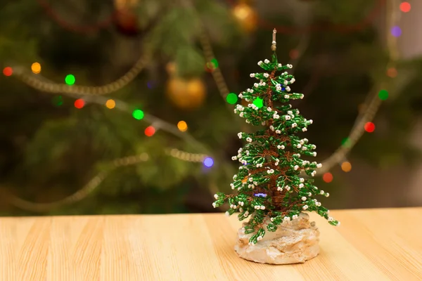 Decorated Christmas small tree on wooden table with glowing background — Stock Photo, Image