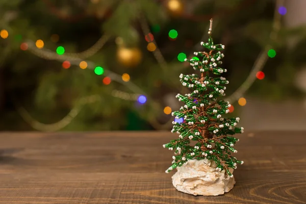 Decorated Christmas small tree on wooden table with glowing background — Stock Photo, Image