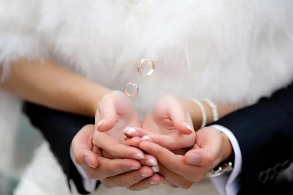 Manos con anillos dorados voladores — Foto de Stock