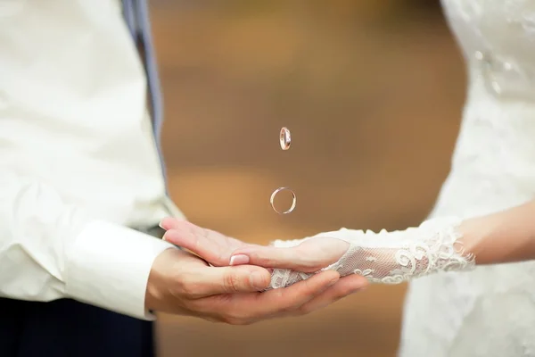 Handen met vliegende gouden ringen — Stockfoto