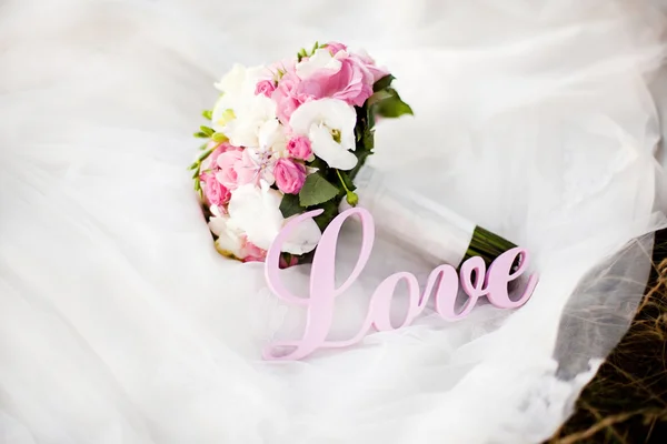 Bouquet de mariage rose et blanc sur la robe avec des lettres — Photo