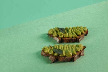 Yeşil fesleğenli avokado makarna, sarımsak ve hindistan cevizi kremalı tam tahıllı ekmek.