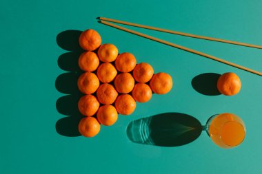 Mandalinalar, bilardo sopası ve bir bardak mandalina suyu gibi makarna taklit eden 16 top şeklinde klasik bir piramit şeklinde bir bilardo masasının üzerine serilmiştir.