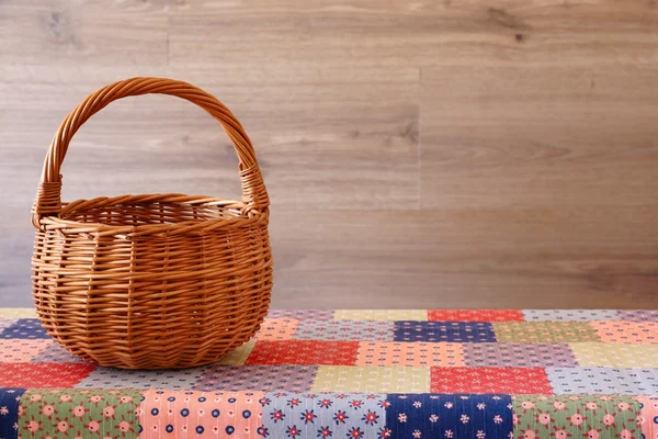 Cesta vacía en un mantel de color. Fondo de madera . — Foto de Stock